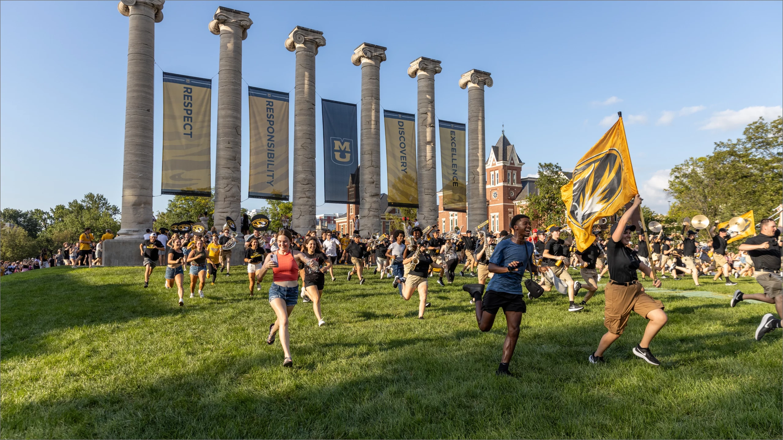 Students running between the columns on the Francis Quad.