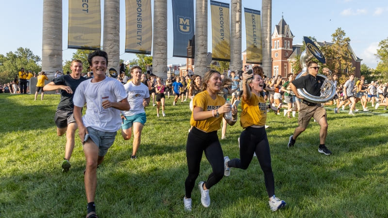 Students running through the columns on the quad at Mizzou
